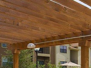 Pool with lounge chairs by apt building The Retreat at CTM Apartments For Rent l Waco TX Apts For Rent