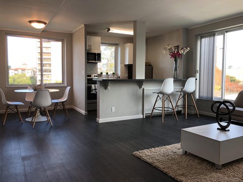 A modern kitchen with white cabinets and a dining table with chairs.