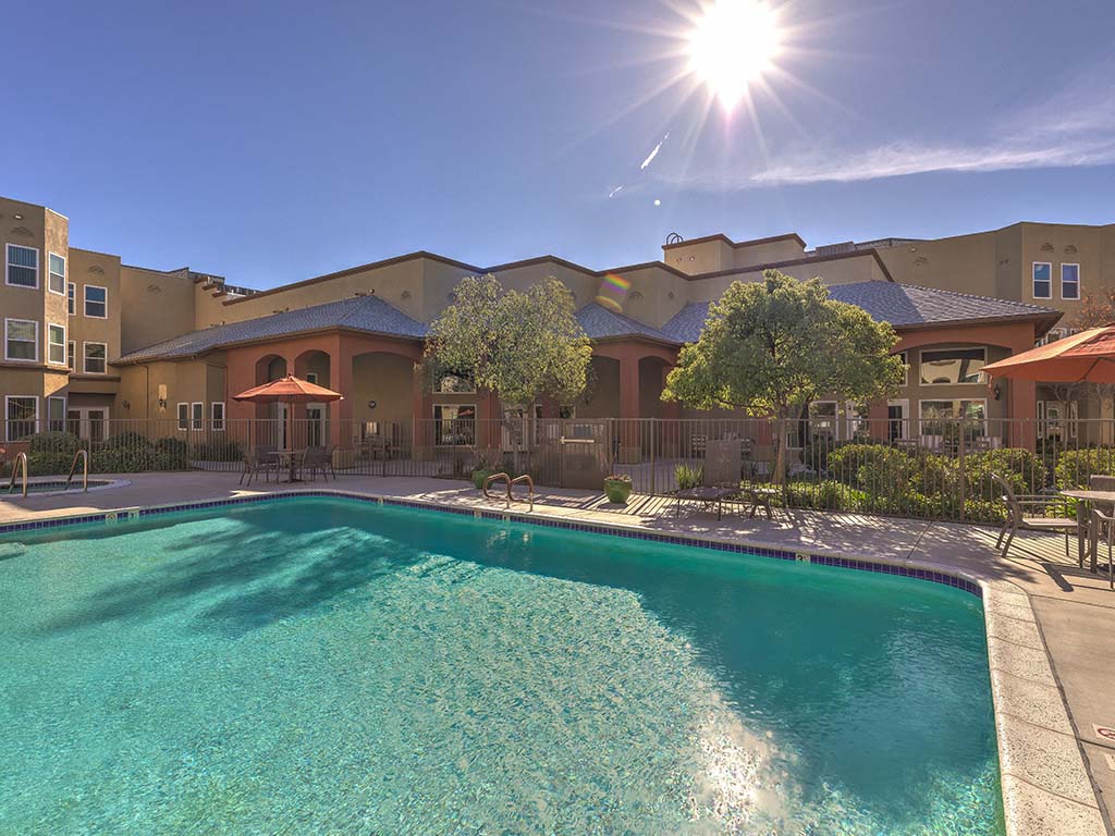 Pool with tables and seating  l Vintage at Bouquet Canyon Senior Apartments