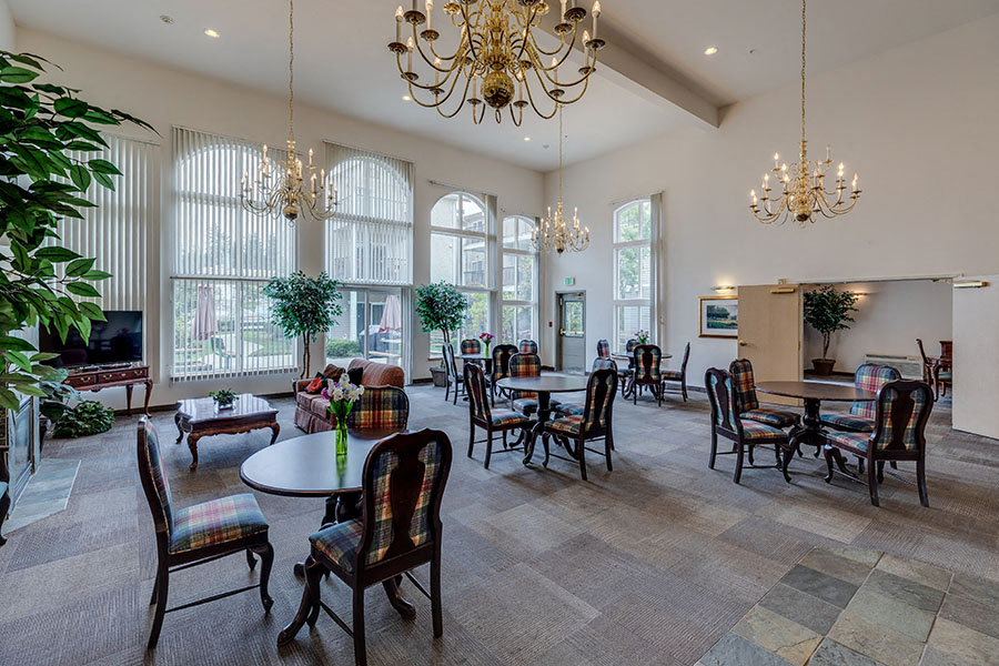 a large living room with tables and chairs and chandeliers