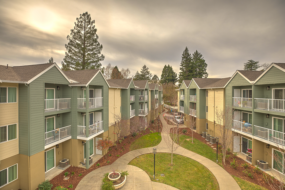 View of exterior of community with grass l Vintage at Napa Senior Apartments