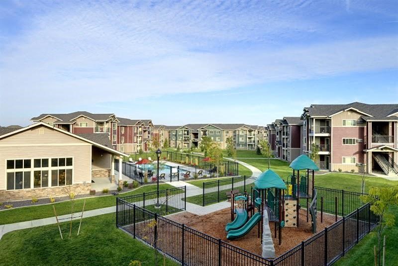 Playground with grass by apt buildings Longmont, CO 99337 | Copper Peak Apt Rentals