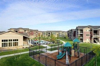 Playground with grass by apt buildings Longmont, CO 99337 | Copper Peak Apt Rentals - Photo Gallery 14