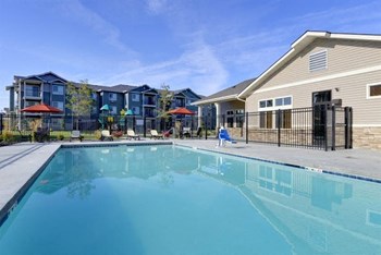 Pool with lounge chairs and apt buildings Copper Peak Apt Rentals | Longmont, CO 99337 - Photo Gallery 17