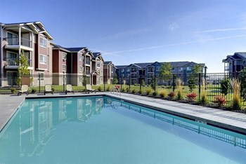 Pool with lounge chairs and apt buildings Copper Peak Apts For Rent | Longmont, CO 99337 - Photo Gallery 18