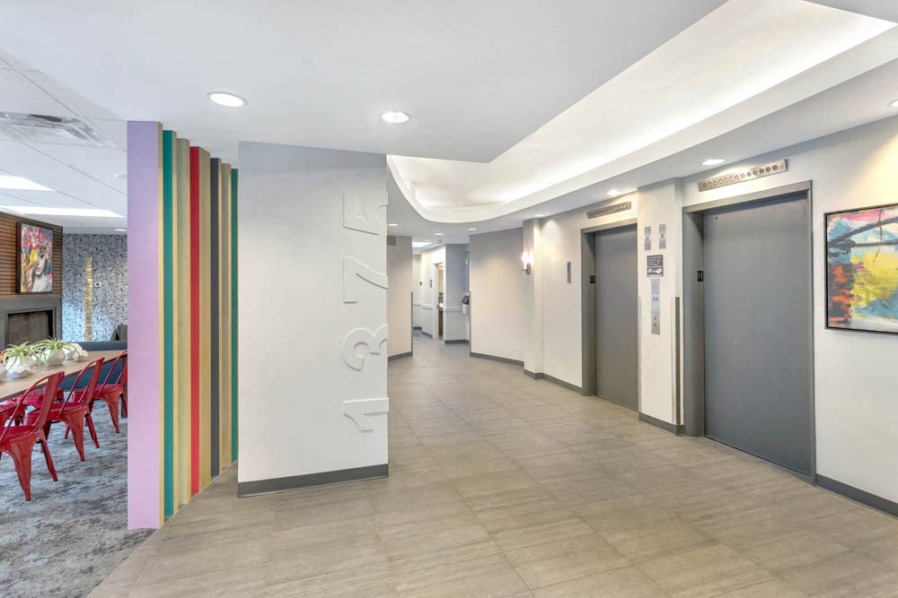 a corridor of elevators and doors in a lobby of a building