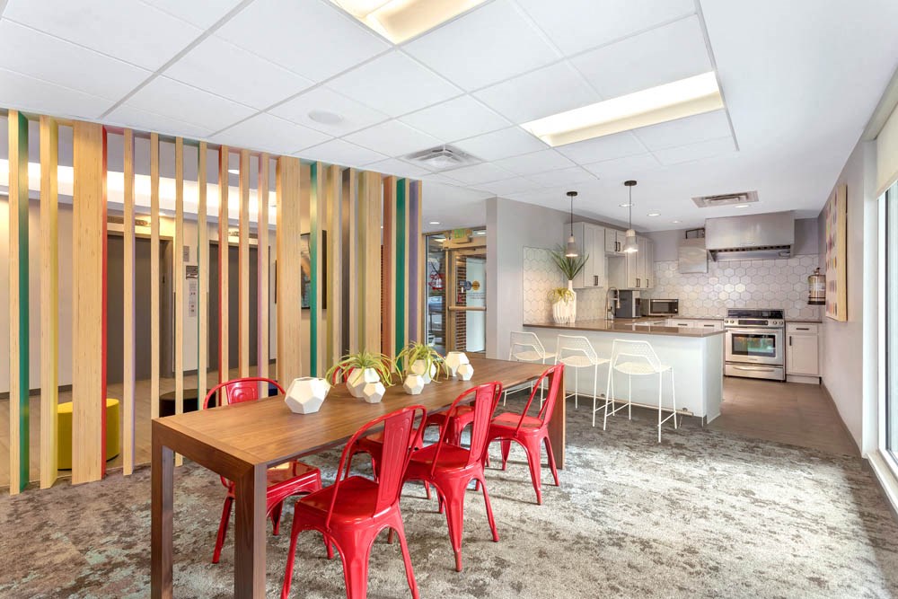 a dining room with a wooden table and red chairs