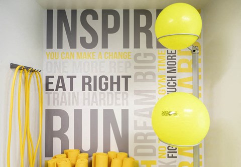 a gym with yellow ping pong balls and a motivational quote on the wall