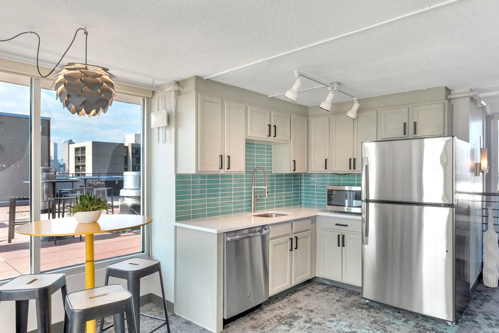a kitchen with white cabinets and a stainless steel refrigerator