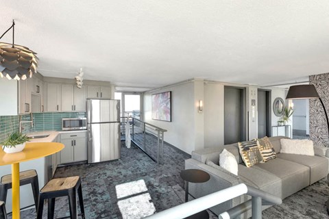 a living room and kitchen with a couch and a table