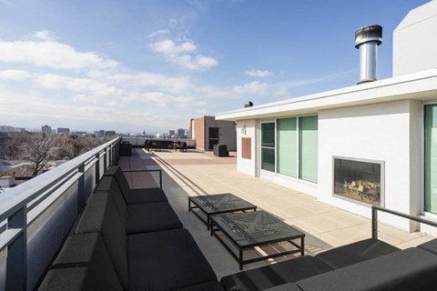 the balcony of the home has a fireplace and benches