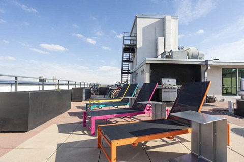 a row of colorful lounge chairs on the roof of a building
