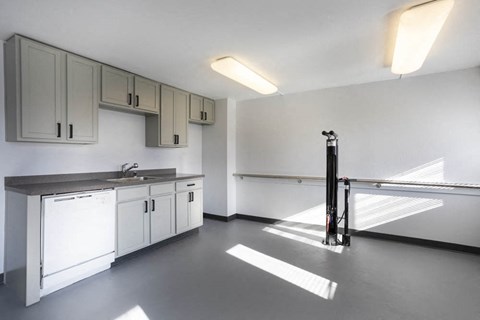 an empty kitchen with white cabinets and a sink