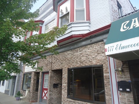 the front of a building with a green and red sign