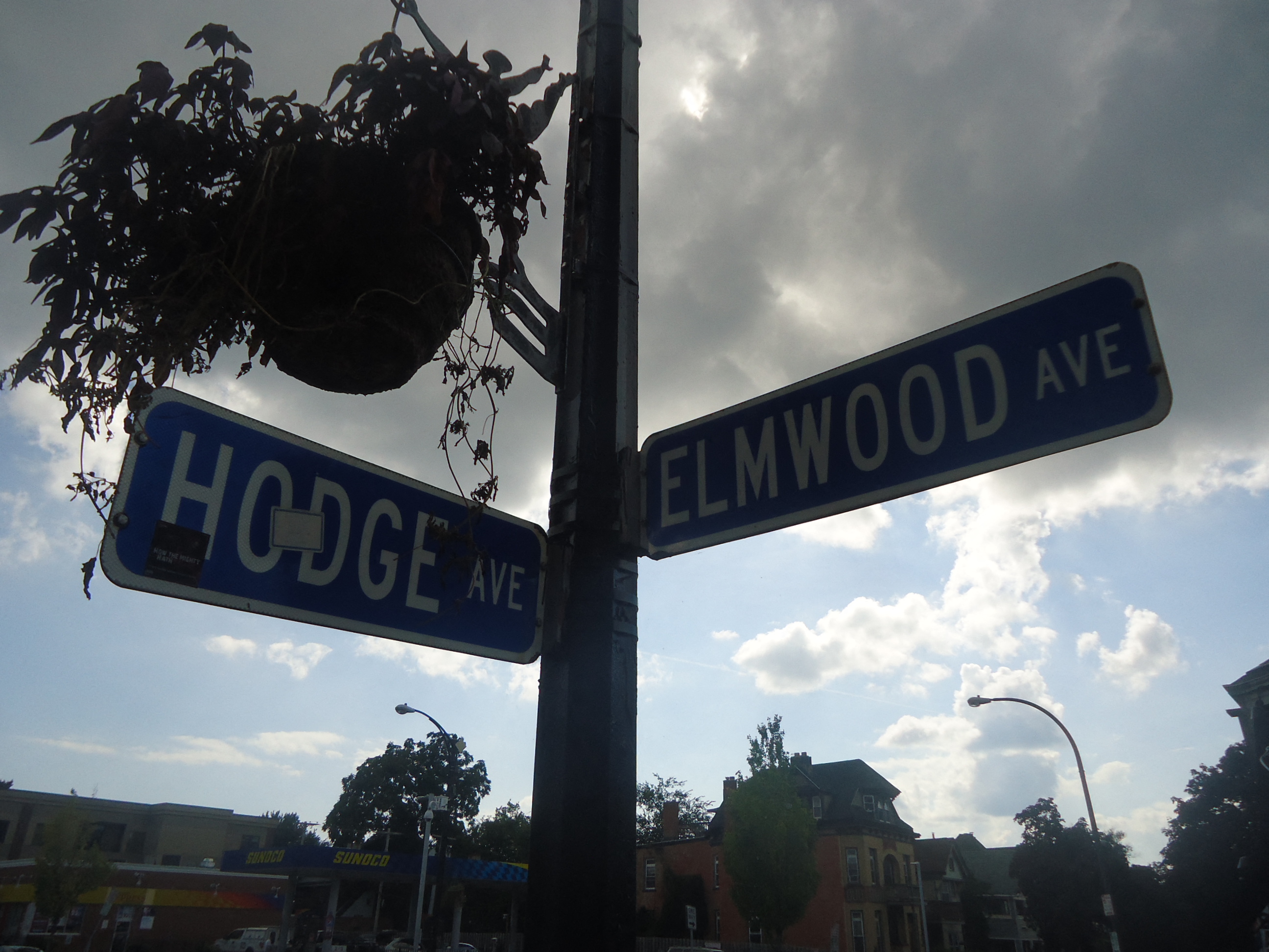 two street signs on a pole next to a street light