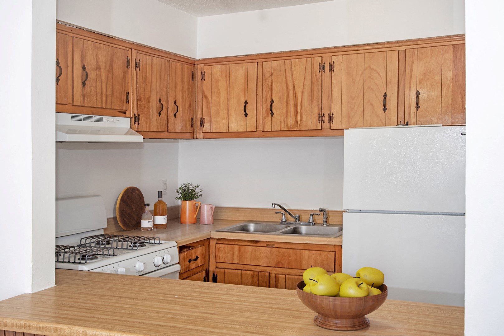 a kitchen with white appliances and wooden cabinets