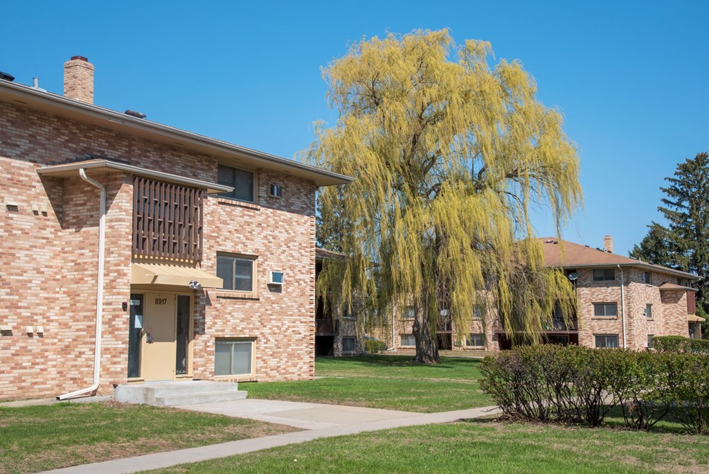 a building with a weeping willow tree in front of it