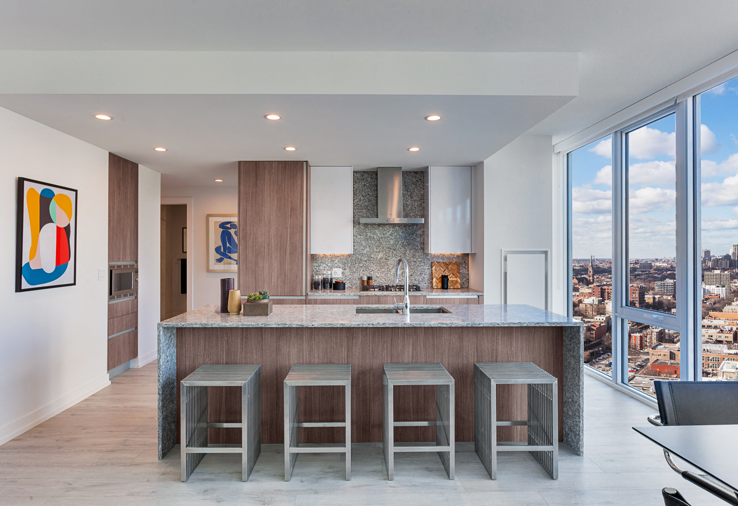 a kitchen with a marble counter top and three stools