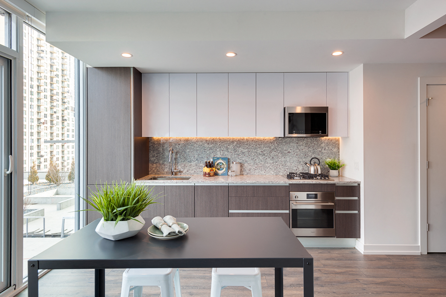 a kitchen with white cabinets and a black table