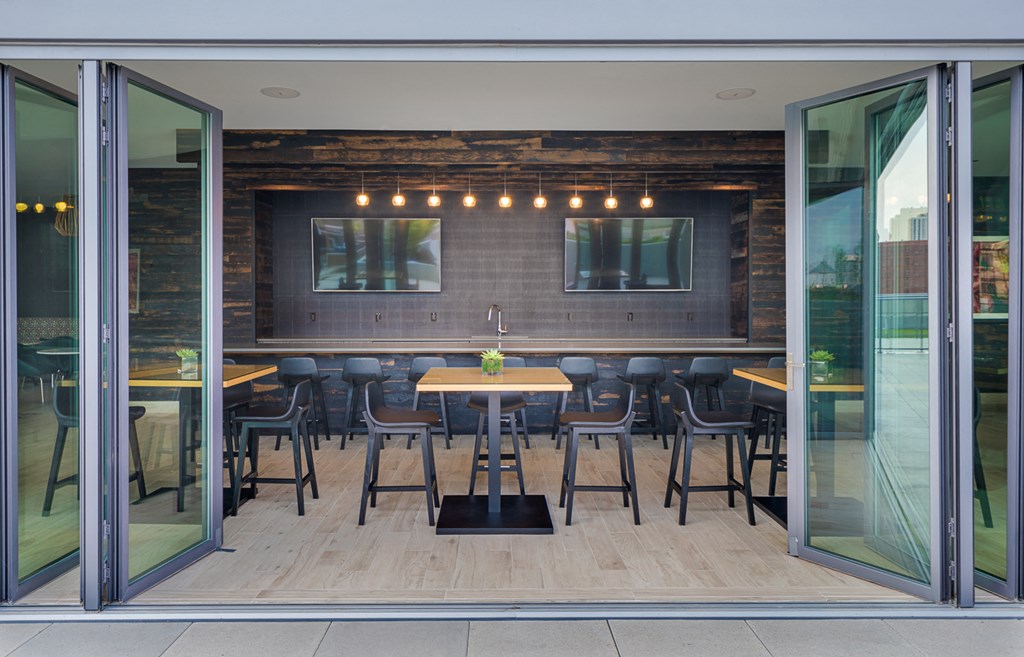 a dining area with tables and chairs in a room with glass doors