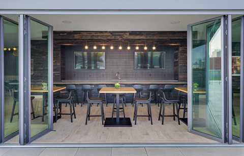 a dining area with tables and chairs in a room with glass doors