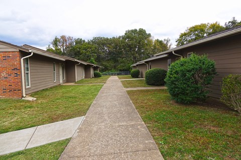 a sidewalk in front of a row of houses