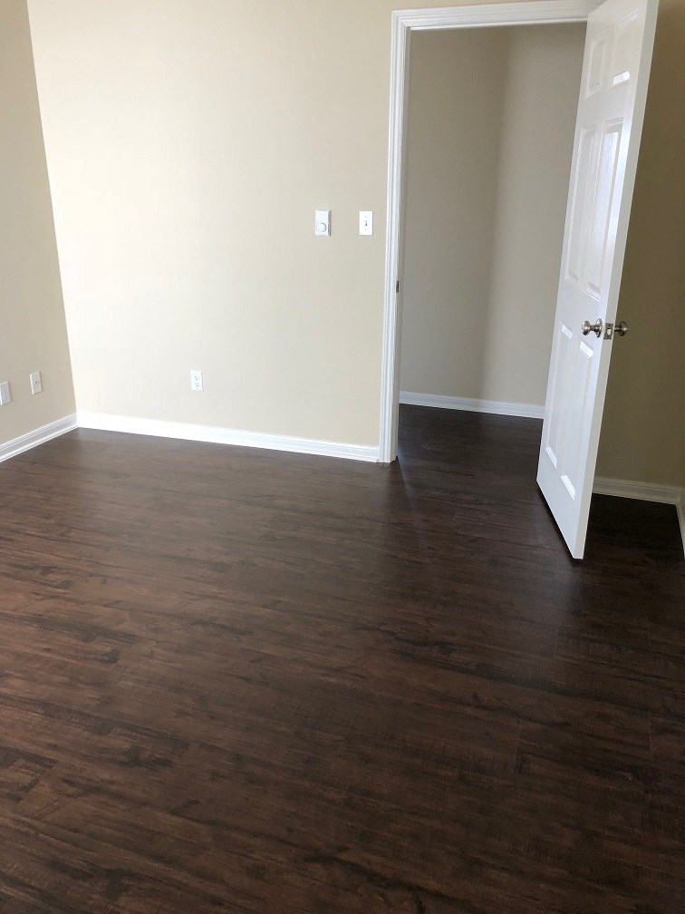 an empty living room with wood floors and a door