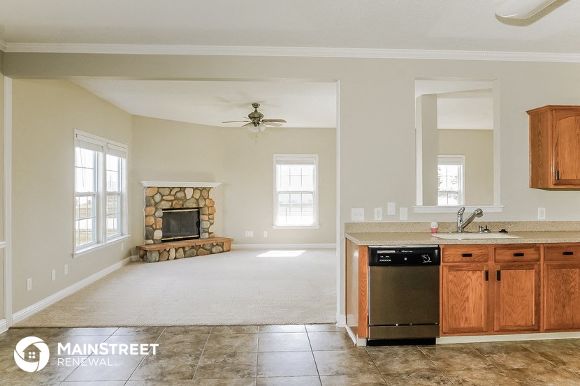 a kitchen and living room with a granite counter top and a fireplace