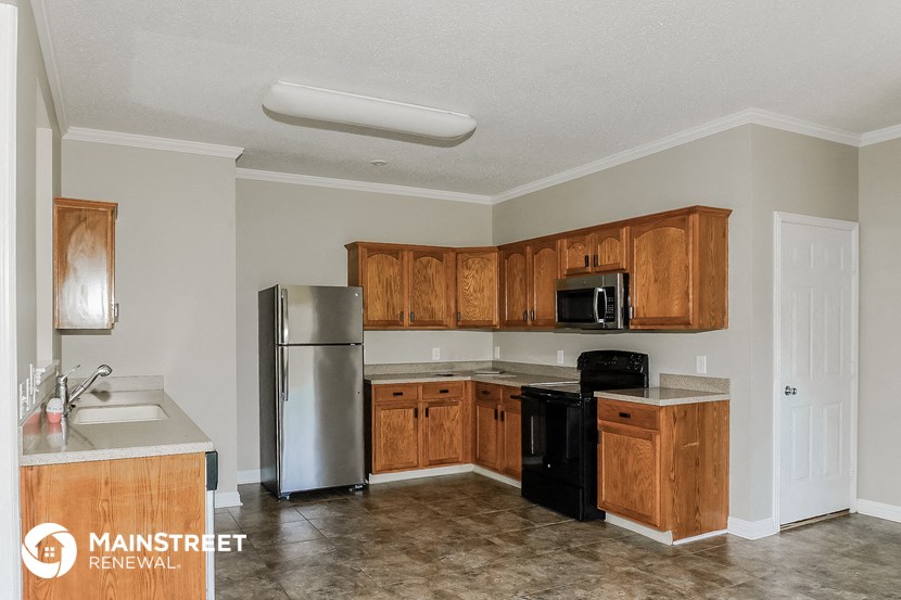 a kitchen with wooden cabinets and a stainless steel refrigerator