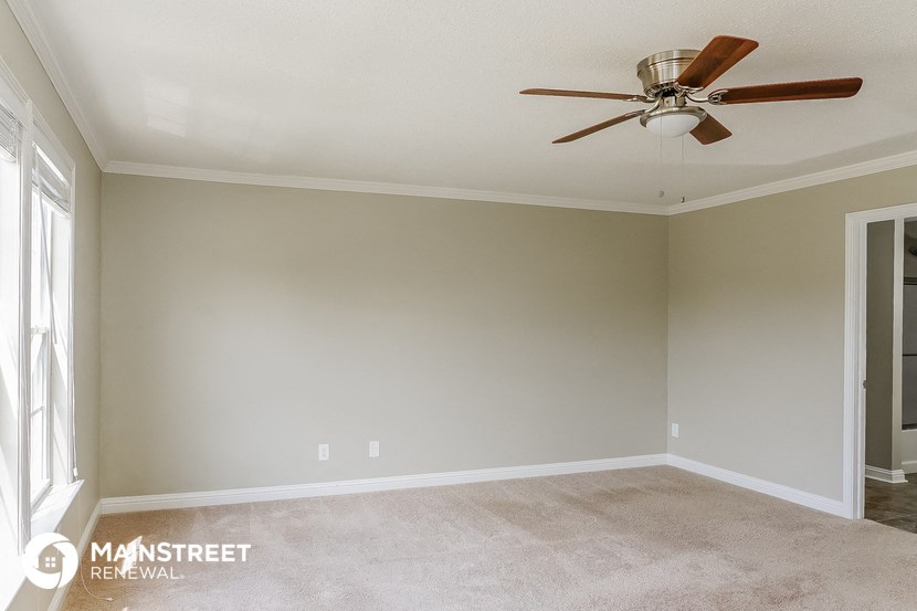 a empty living room with a ceiling fan