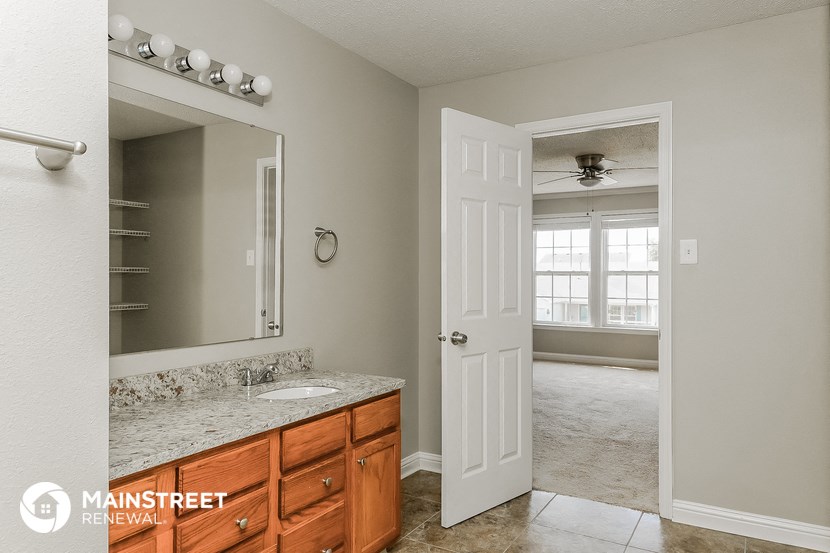 a bathroom with a sink and a mirror and an open door