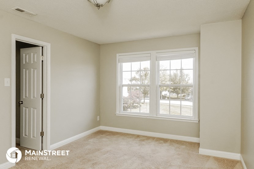 an empty room with two windows and a white door