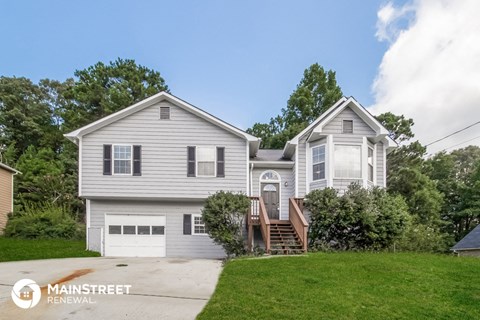 a white house with a front yard and a driveway