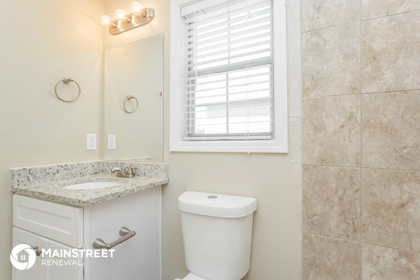 a bathroom with a toilet and a sink and a window