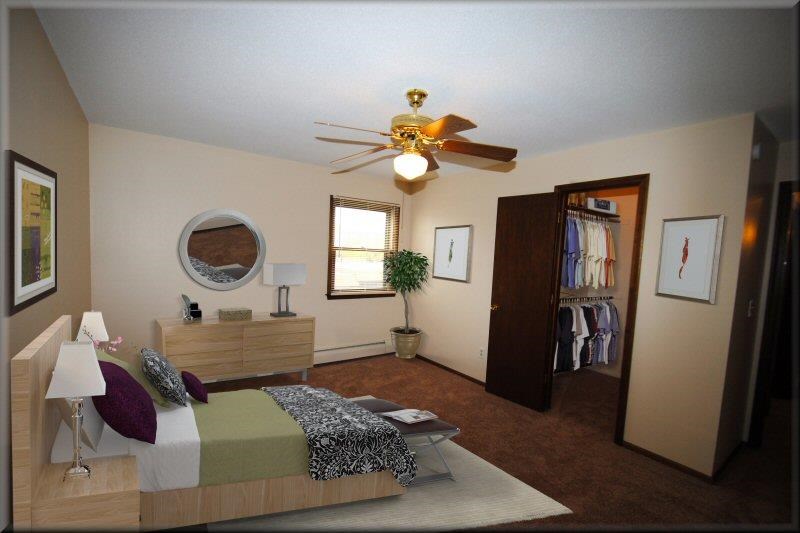 a bedroom with a bed and a ceiling fan