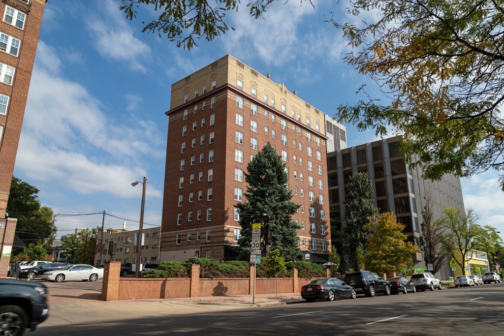 a tall brick building on the corner of a city street