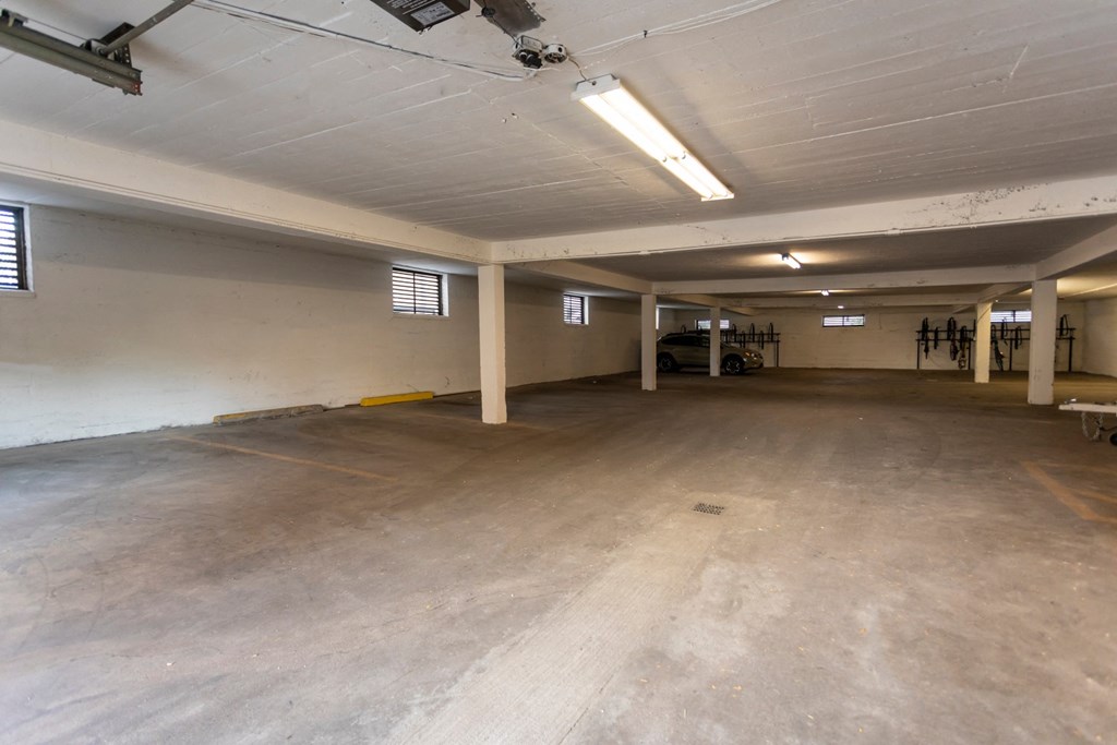 the interior of a parking garage with a concrete floor and white walls