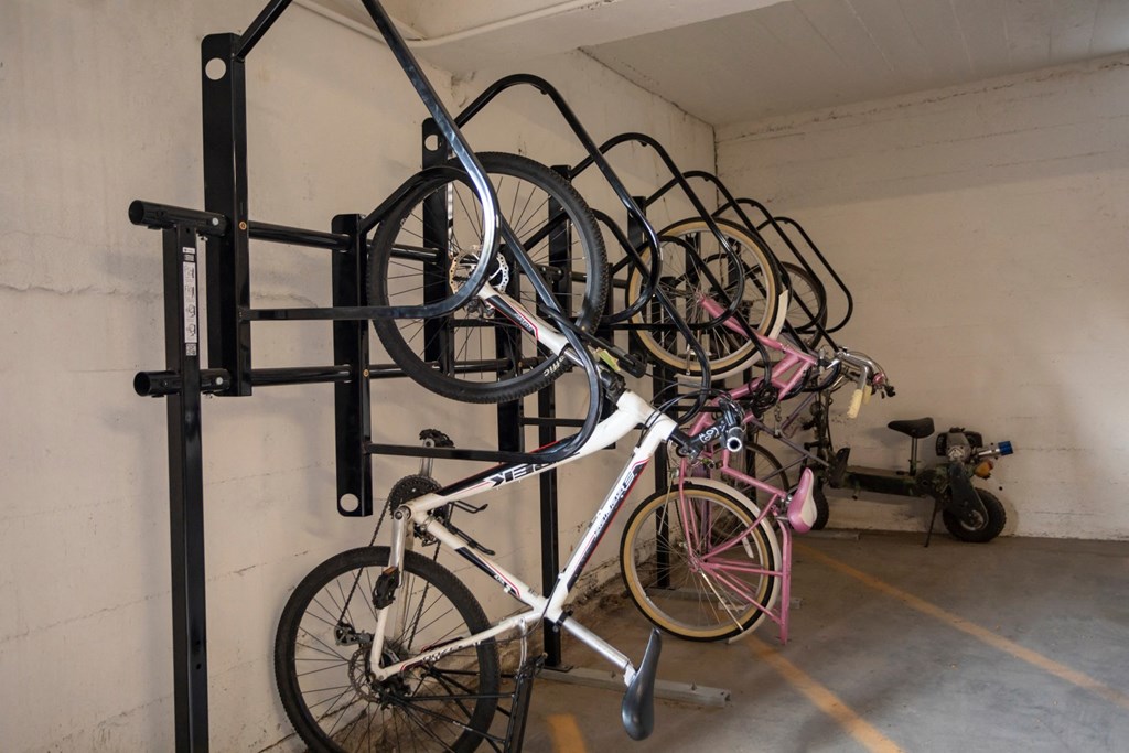 a group of bikes hanging on a bike rack in a garage