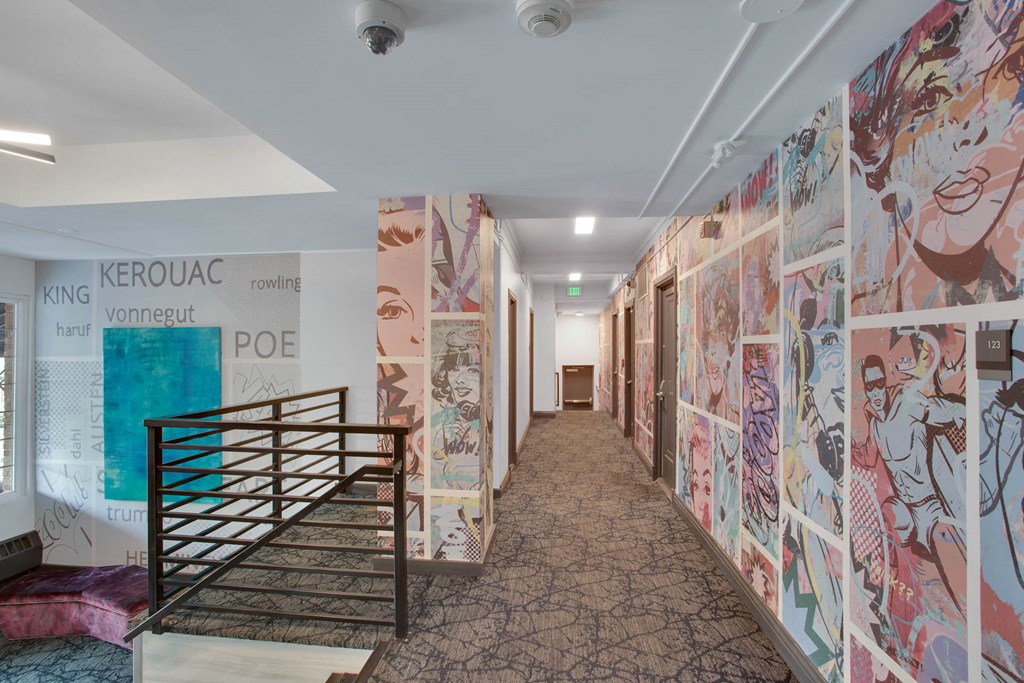 a hallway with paintings on the wall and a staircase