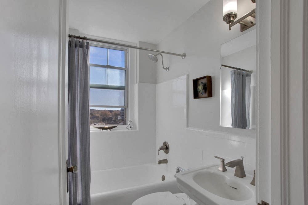 a white bathroom with a sink and a window