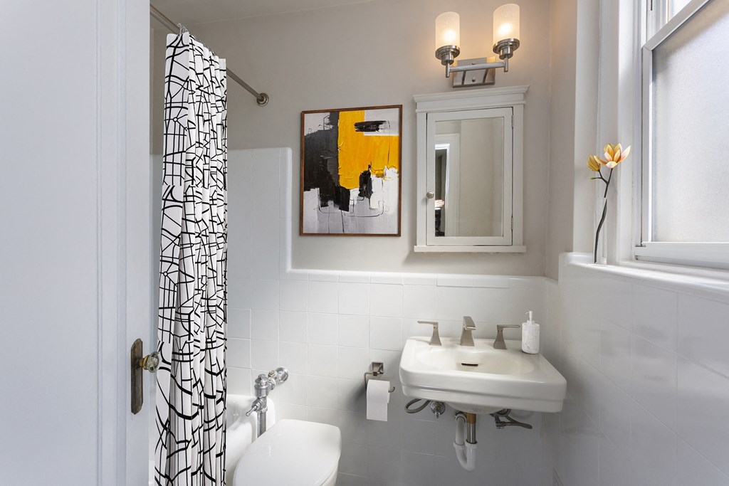 a small bathroom with a sink and a shower curtain