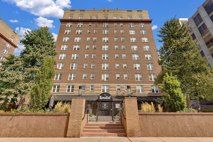 a large brick building with stairs and a gate in front of it
