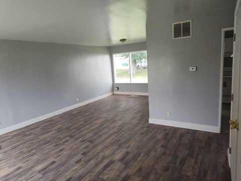 A room with wooden flooring and a window.