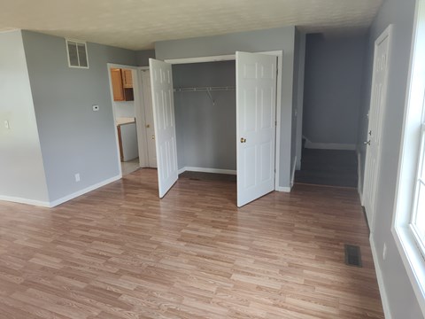 A room with a white door and a wooden floor.