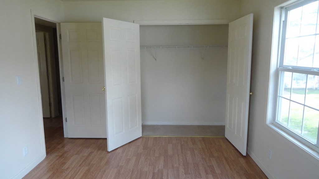 an empty room with two closets and a window