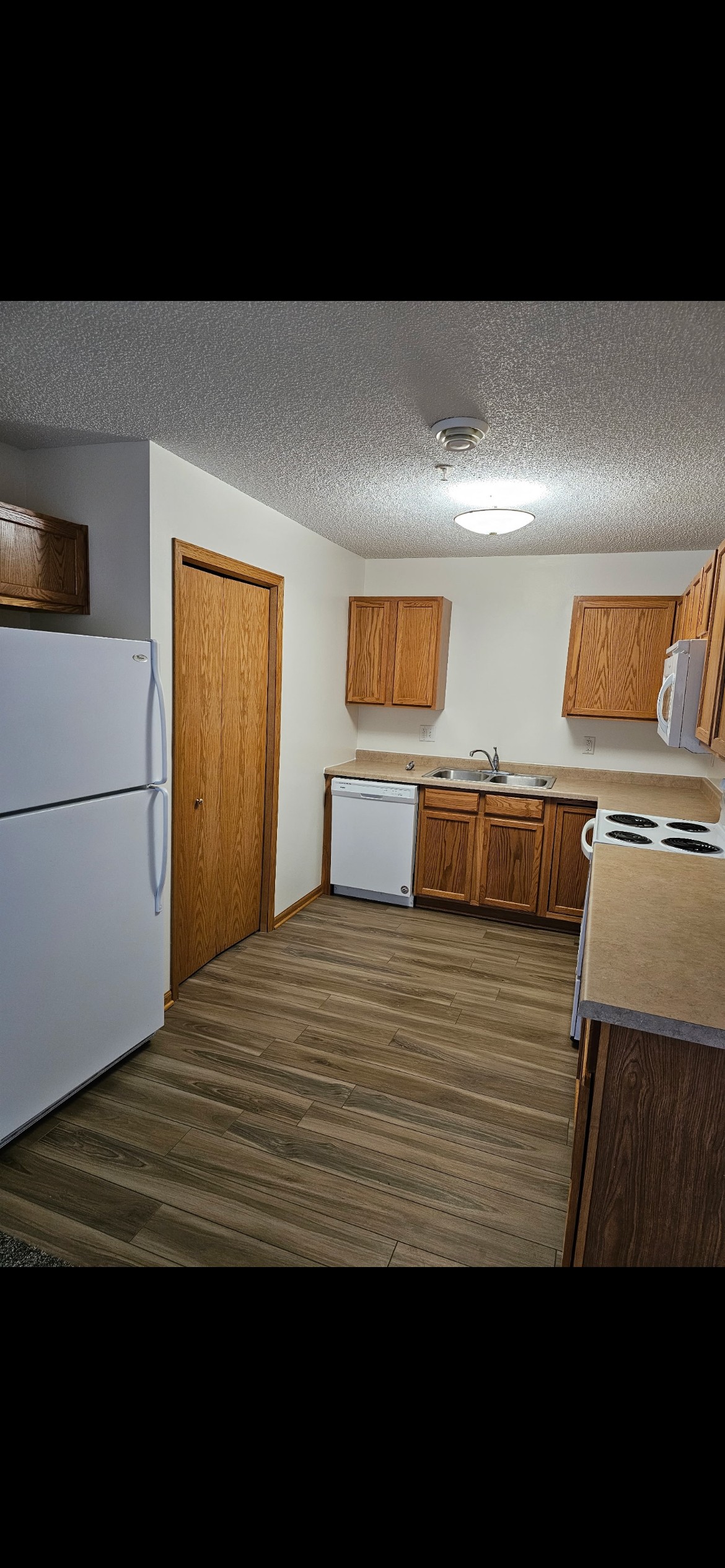 A kitchen with wooden cabinets and a white refrigerator.