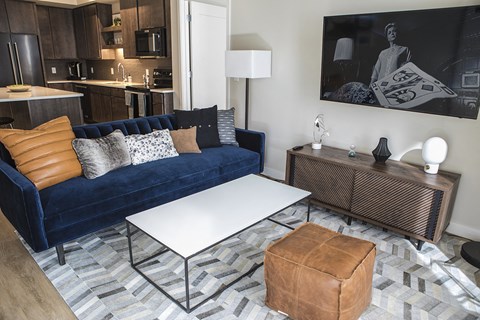 A living room with a blue couch and a white coffee table.