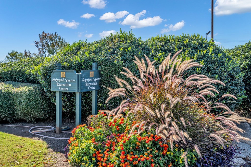 A sign for Magnet Square Recreation Center is in front of a hedge.