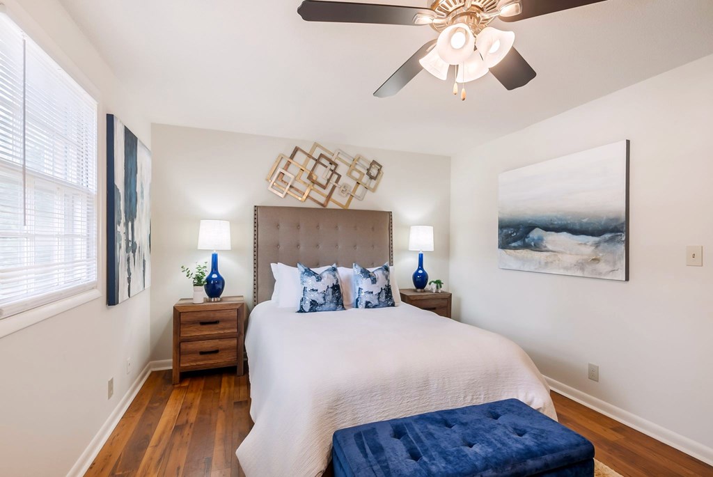 A bedroom with a large bed and a ceiling fan.