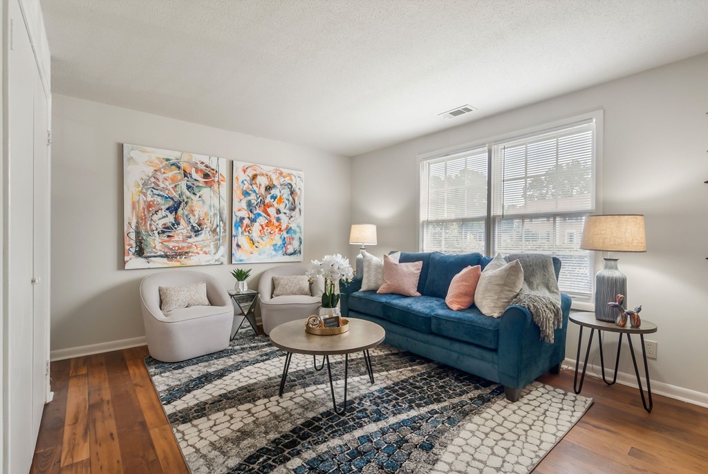 A living room with a blue couch, two chairs, and a coffee table.